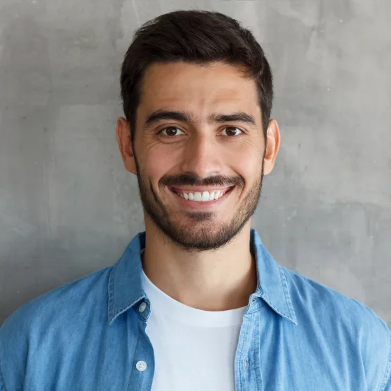 Smiling man with short dark hair wearing a blue shirt