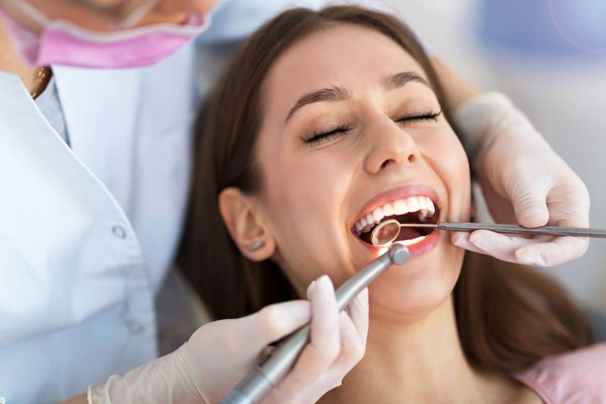 Dentist examining patient's teeth during oral surgery consultation in Brooklyn.