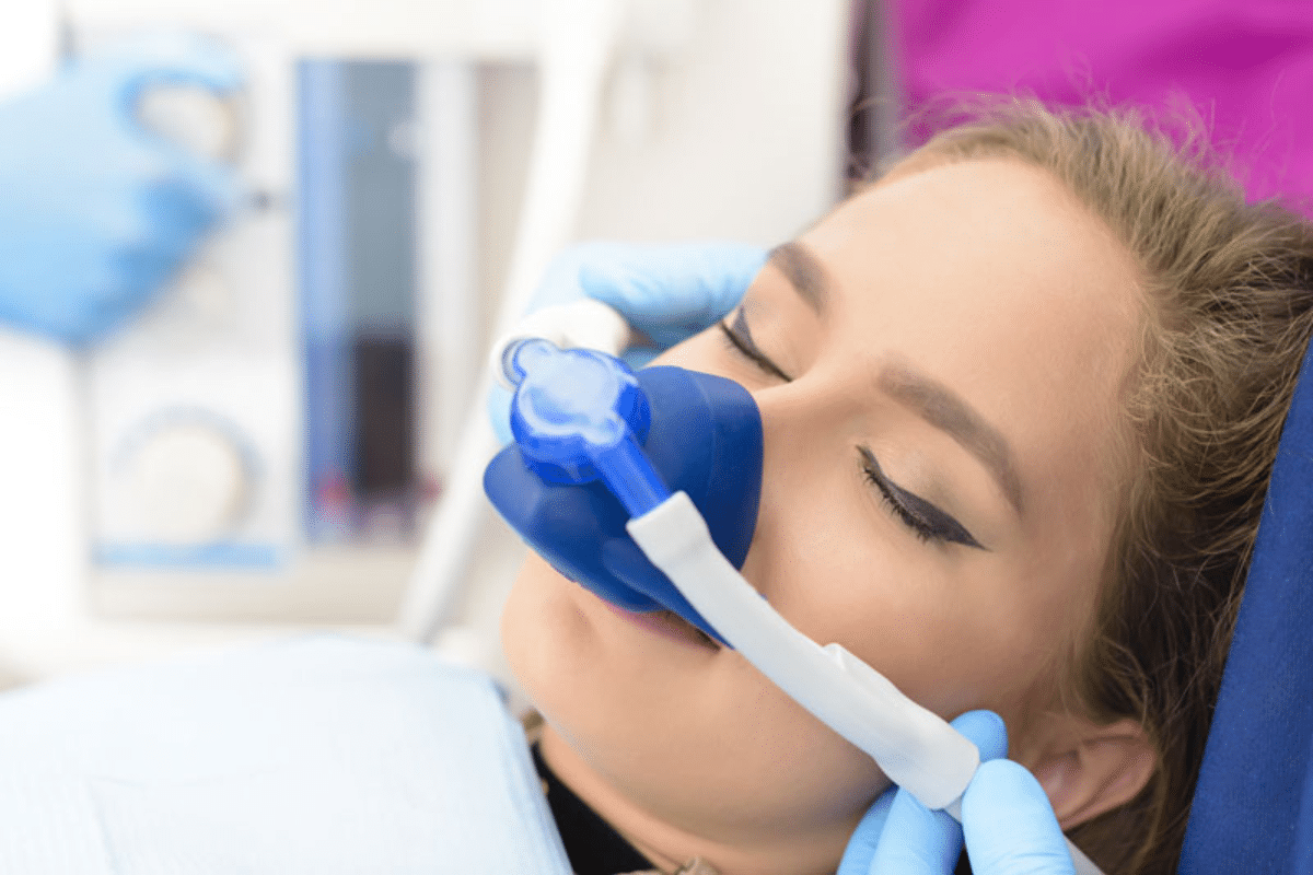 Patient using oral sedation mask during dental treatment in Brooklyn.