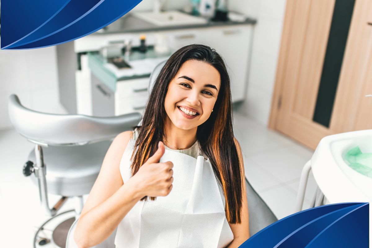 Happy patient giving thumbs up in modern dental office treatment room.