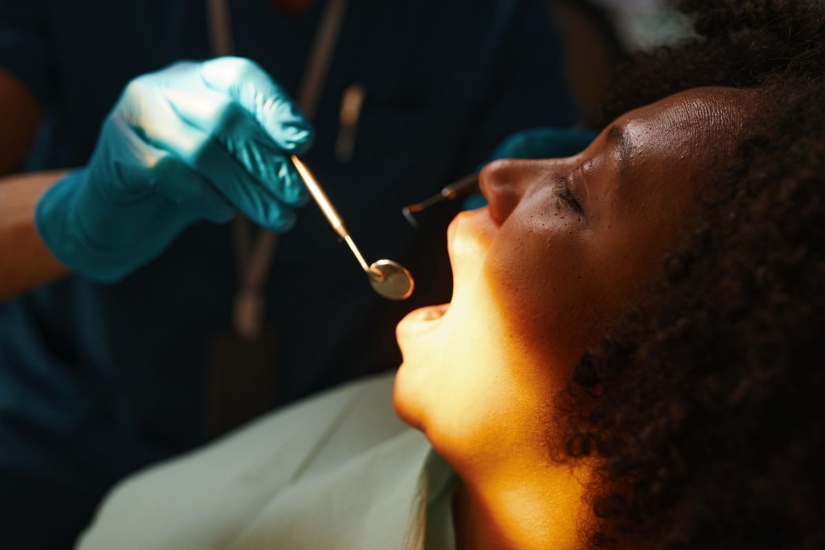Dentist applying sedation to patient's mouth during dental procedure in Brooklyn.
