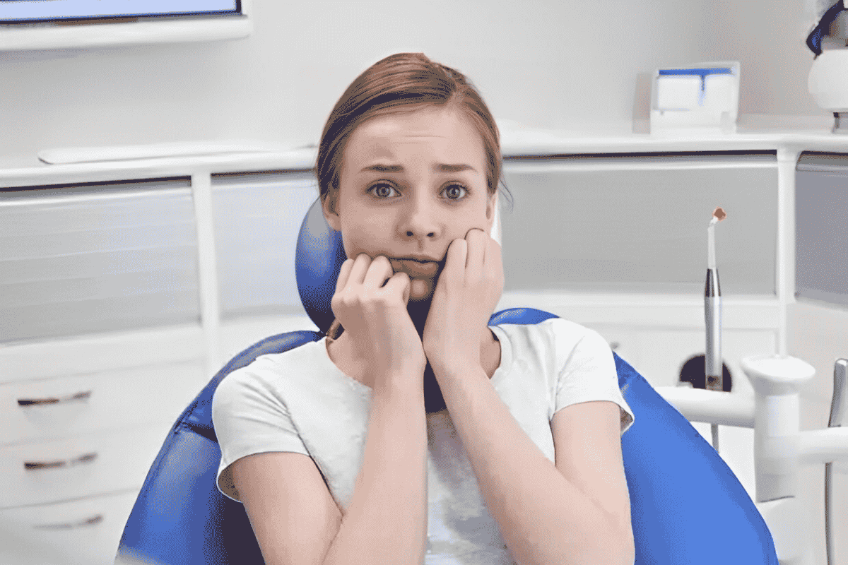 Anxious patient in dental office chair showing signs of dental anxiety and nervousness.