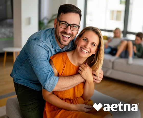 Couple smiling together with Aetna dental insurance branding