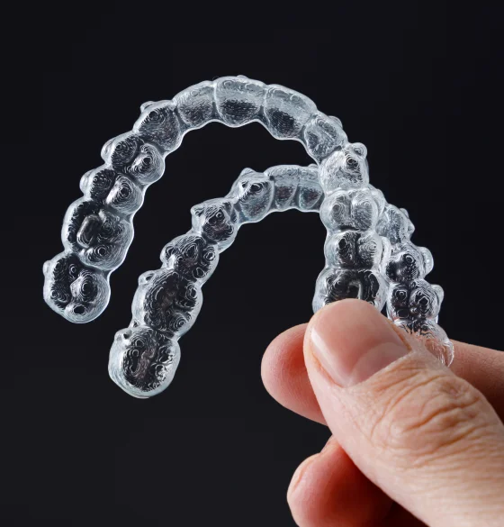 Hands holding a clear dental aligner