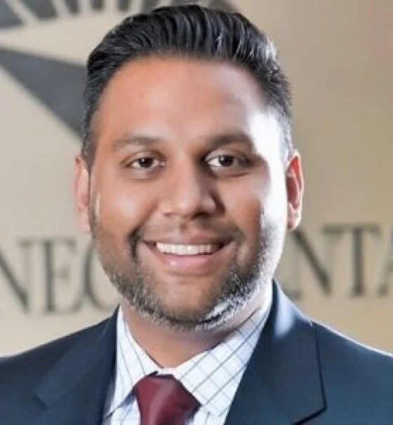 Professional headshot of a male dental professional wearing a suit and tie