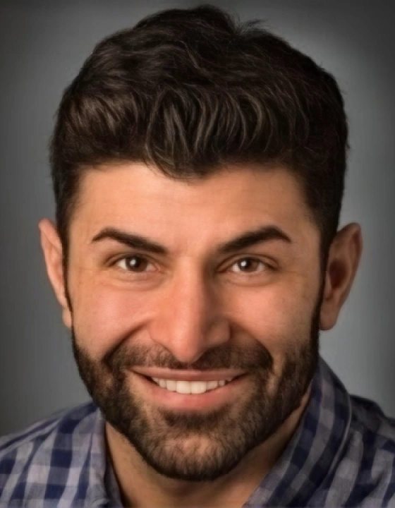 Professional headshot of a male dental professional with a beard