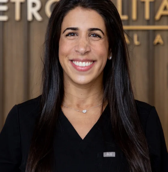 Professional headshot of a smiling female dental professional with long dark hair