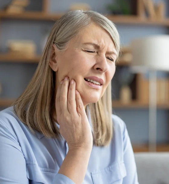 Woman touching her cheek during a dental examination