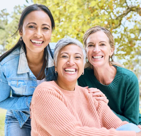 Group of three smiling women standing outdoors