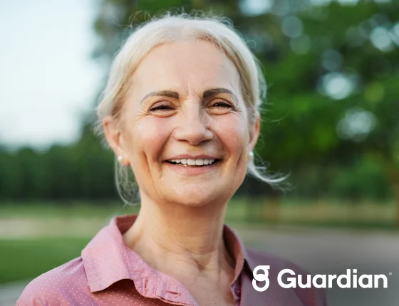 Smiling woman with Guardian dental insurance branding