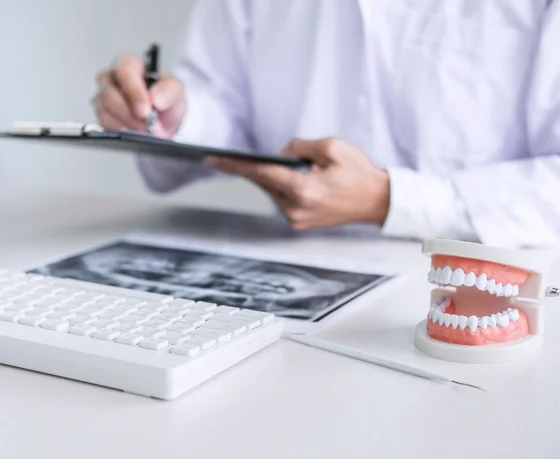 Dental insurance and financing documents with calculator and pen