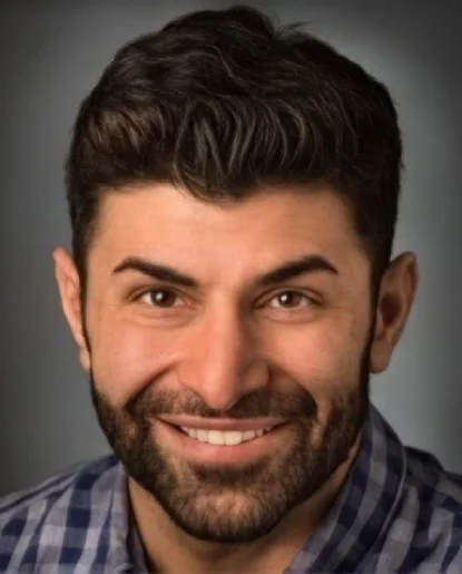 Professional headshot of a man with a beard wearing a dark shirt