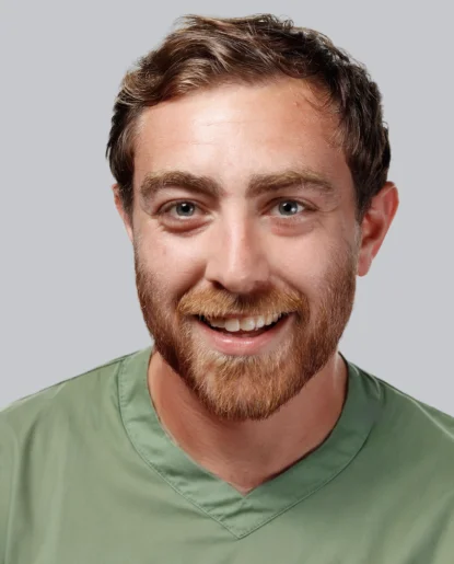 Professional headshot of a man with a beard wearing a green shirt