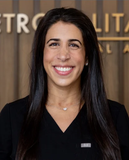 Professional headshot of a woman with long dark hair wearing a black top