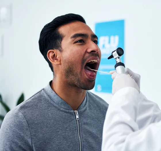 Male patient having his mouth examined during an oral health screening