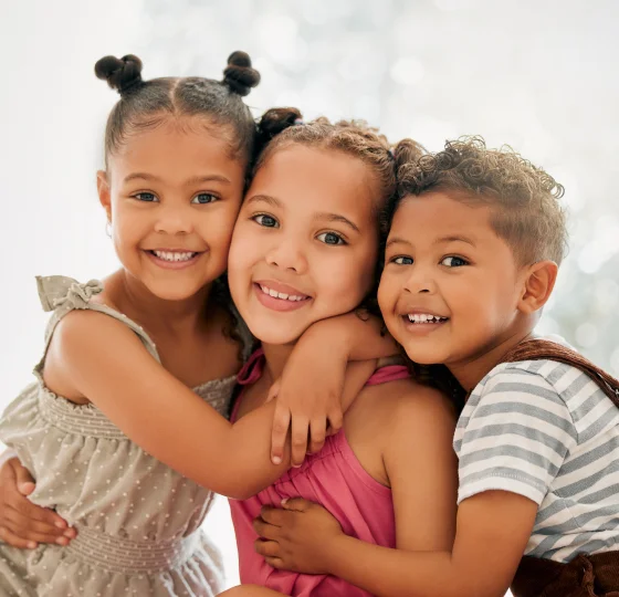Three children smiling together