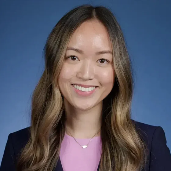 Professional headshot of a woman with long hair wearing a black top