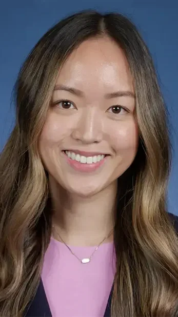 Professional headshot of a woman with long hair wearing a black top