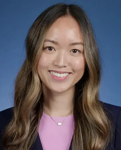 Professional headshot of a woman with long hair wearing a black top